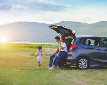 Joyous family with a happy little girl with family sitting in the car.Ca