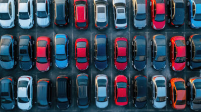 Aerial shot of assorted cars in a dealership lot during sunset